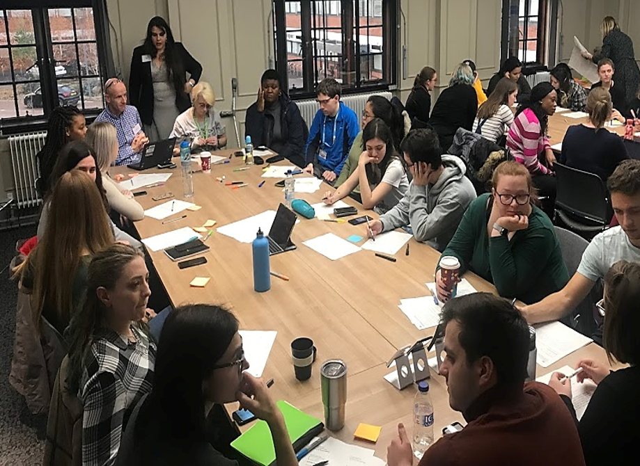 Research team members and participants around a board table as part of the campus cell broadcast trials