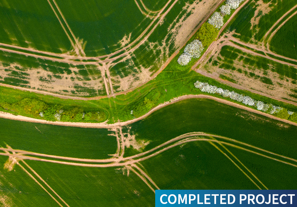 Aerial view of a green field with track marked overlaid with text saying Completed Project